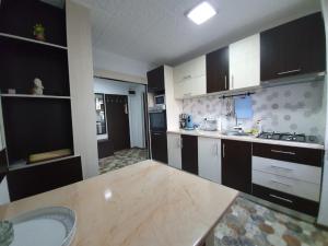 una cucina con armadi in bianco e nero e un lavandino di Apartment Ada Kaleh a Orşova
