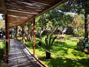 a wooden walkway leading to a garden with a fence at S'Abba Druche rooms in Bosa