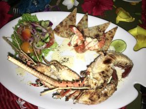 a plate of food with a lobster and a salad at Shangri-Lanka Village in Tissamaharama