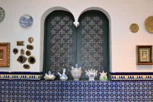 a shelf with vases and plates on a wall with a window at Hotel Villegas in Valencia de Don Juan
