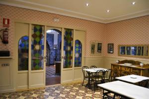 Hotel Villegas في فالنسيا دي دون خوان: مطعم بطاولات وكراسي ونوافذ زجاجية ملطخة