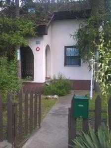 a house with a fence in front of it at ZENITH APARTMAN in Gárdony
