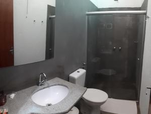 uma casa de banho com um lavatório, um WC e um espelho. em Pousada Nuporanga em Nuporanga