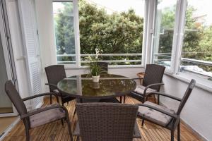 诺瓦利娅Apartment Bobby的有窗户的房间里有一张桌子和几把椅子