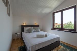 a bedroom with a bed with white sheets and a window at Apartment Lungera in Pula