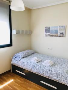 a bedroom with a bed with two towels on it at Apartamento Bonitas Vistas in Luanco