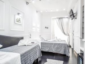 2 camas en una habitación blanca con ventana en La Locanda di Piazza del Popolo, en Roma