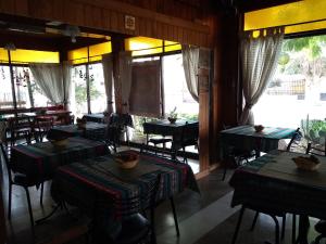 a dining room with tables and chairs and windows at Hotel La Marina in Villa Carlos Paz