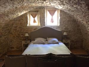 a bedroom with a bed with two windows and a couch at LOCUS AMOENUS in Lirac