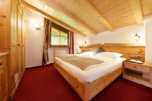 1 dormitorio con 1 cama grande de madera en una habitación en Nestlhof, en Racines