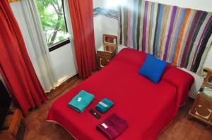 Un dormitorio con una cama roja con dos bolsas. en Hotel La Marina en Villa Carlos Paz