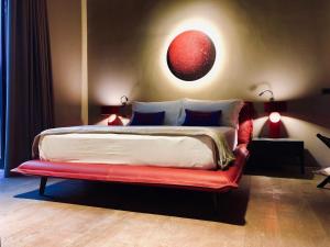 マンドゥーリアにあるMasseria Li Reniのベッドルーム1室(大型ベッド1台、赤いベンチ付)