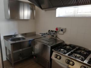 a small kitchen with a stove and a sink at Opera Boutique Rooms in Monreale