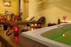 a bath tub in a room with a bed at Pousada dos Amores in Visconde De Maua