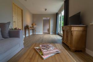 een woonkamer met een bed en een boek op de vloer bij Bed & Breakfast Bos en Weide in Boxtel
