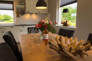 een tafel met een fles wijn en wijnglazen bij Bed & Breakfast Bos en Weide in Boxtel +7 foto's