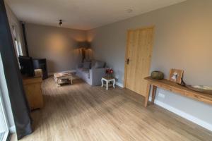 een woonkamer met een bank en een televisie bij Bed & Breakfast Bos en Weide in Boxtel