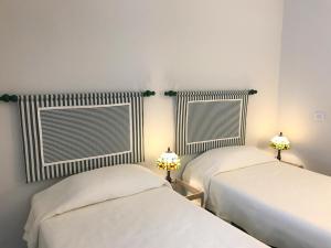 Duas camas num quarto com paredes brancas e janelas em Una vista inolvidable em Corralejo