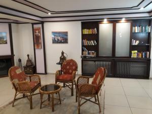 a waiting room with chairs and a table and bookshelves at Hali Hotel in Istanbul
