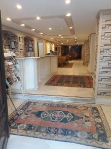 a lobby with a rug on the floor and a counter at Hali Hotel in Istanbul
