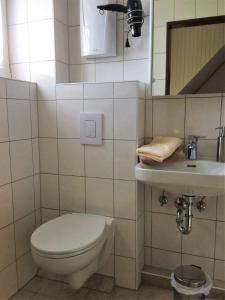 łazienka z toaletą i umywalką w obiekcie Huus Störtebeker w mieście Dornumersiel