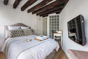 a bedroom with a bed with a tv on the wall at CosyCocoon in Paris