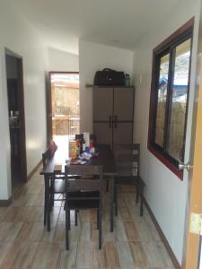 a dining room with a table and chairs and a window at Villa Viray in Baguio