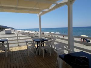 アシェーアにあるCasa Vacanze un sogno al mareの- ビーチのデッキ(テーブル、椅子付)