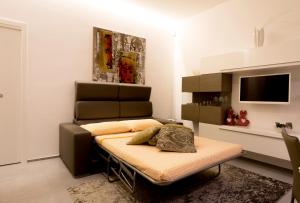 ein Wohnzimmer mit einem Bett und einem TV in der Unterkunft Quattro Palme in Marina di Ragusa