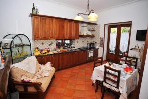 eine Küche mit Holzschränken sowie einem Tisch und Stühlen in der Unterkunft Casa Gentile in Agerola