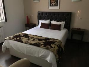 um quarto com uma cama grande e uma cabeceira preta em Casas Do Zagão - Turismo Rural em Carregal do Sal