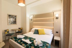 1 dormitorio con 1 cama con toallas en DaVinci Relais, en Roma