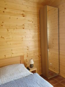 a bedroom with a bed and a wooden wall at Sport-hotel Šibeniční vrch in Mnichovice