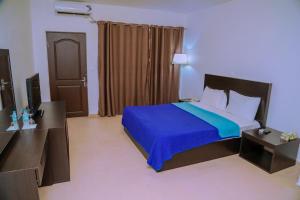 ein Hotelzimmer mit einem Bett mit einer blauen Decke in der Unterkunft Riviera Taouyah Hotel in Conakry + 32 Fotos
