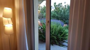 a sliding glass door with a view of a garden at Villa Claudia in Quiliano