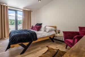 a bedroom with a bed and a couch and a window at Sofia Boutique Hotel in Domaša Dobrá
