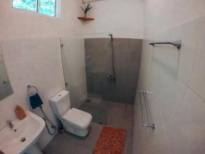 a bathroom with a shower and a toilet and a sink at Green Hill Mirissa in Mirissa