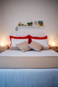 a bedroom with a bed with red and white pillows at Oikia Eleanthi - Beachfront Garden Home! in Mitikas