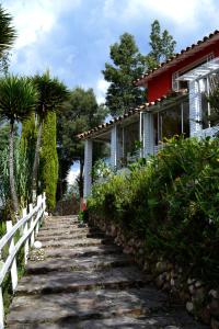 um caminho que leva a uma casa com uma cerca em Cabaña Villa del Viento em Paipa