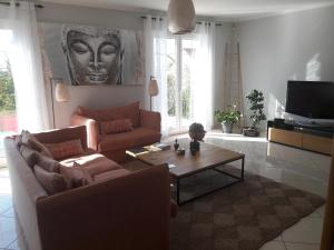 een woonkamer met 2 banken en een salontafel bij Villa de charme, séjour chez l'habitant in Andrésy