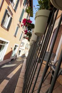 a fence with potted plants on the side of a building at Le Finestre sul Borgo Rooms in Peschiera del Garda