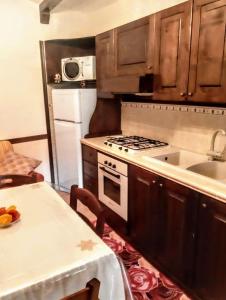 uma cozinha com um fogão, um lavatório e uma mesa em Casa vacanze a Barrea em Barrea