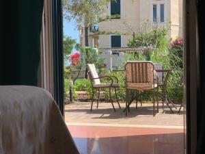 a bedroom with a door open to a patio with chairs at Villino Eleonora in Parghelia