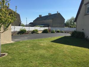 a driveway in a yard with a white fence at B&B de Saint Come de Fresné in Saint-Côme-de-Fresné