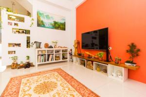 a living room with orange walls and a flat screen tv at 曉翠軒親子民宿 in Wujie