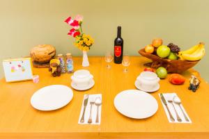 a table with white plates and a bottle of wine at 曉翠軒親子民宿 in Wujie