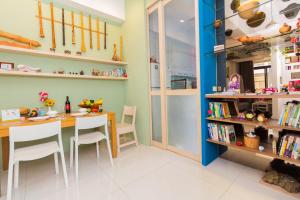 a dining room with a table and chairs and bookshelves at 曉翠軒親子民宿 in Wujie