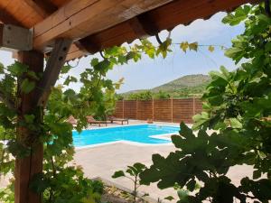uma vista para uma piscina através das árvores em Apartment Smilje em Šibenik