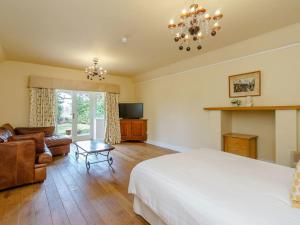 a bedroom with a bed and a couch and a television at The Kingsley at Eversley in Eversley