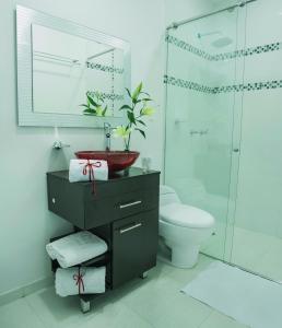 a bathroom with a sink and a toilet and a shower at La Cabrera Hotel Boutique in Neiva